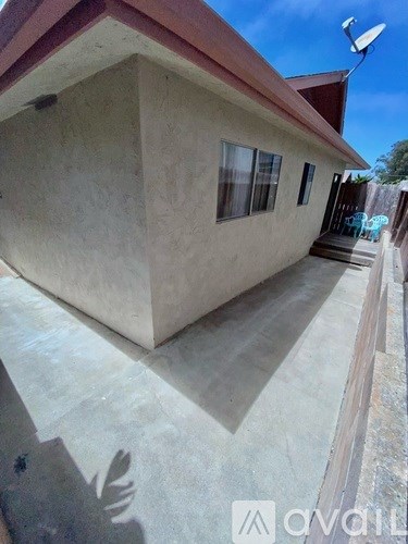 A house with a red roof and a concrete wall.
