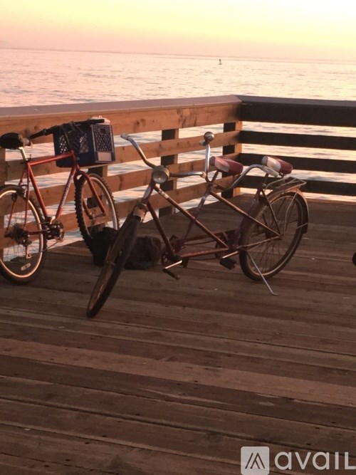 A bicycle is parked on a wooden dock by the water.