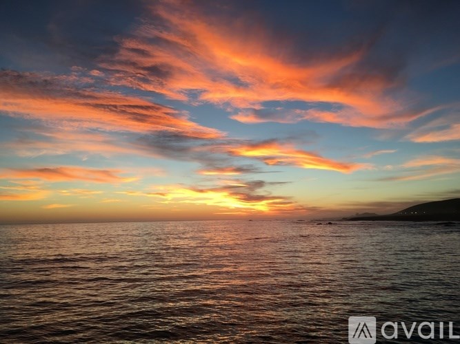 A beautiful sunset over the ocean with vibrant orange and pink hues in the sky.