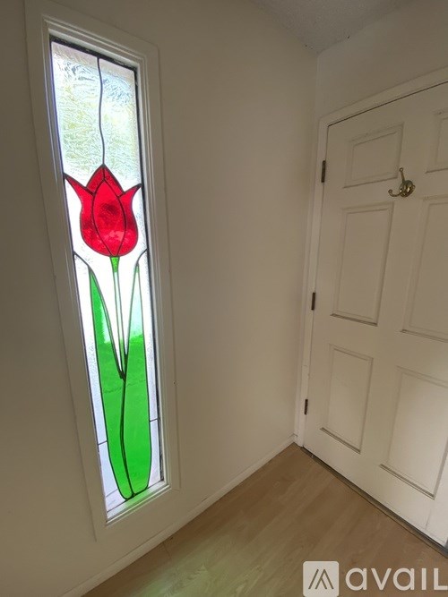 A red tulip is in a stained glass window.