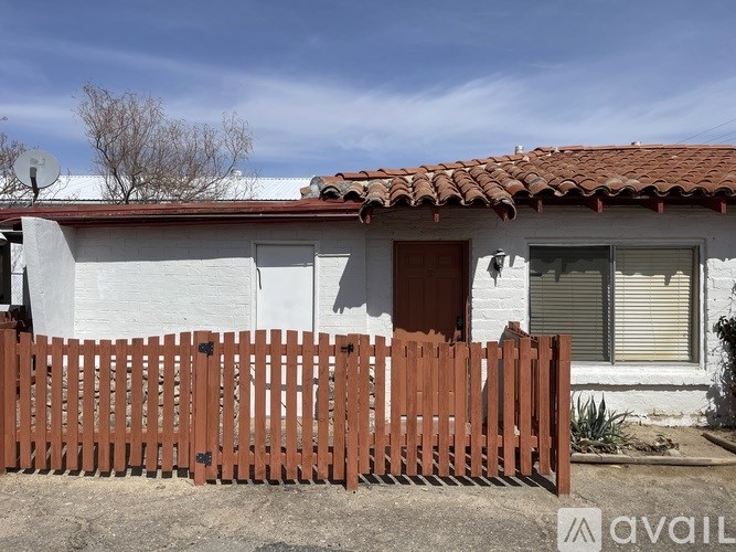 A white house with a brown fence in front.