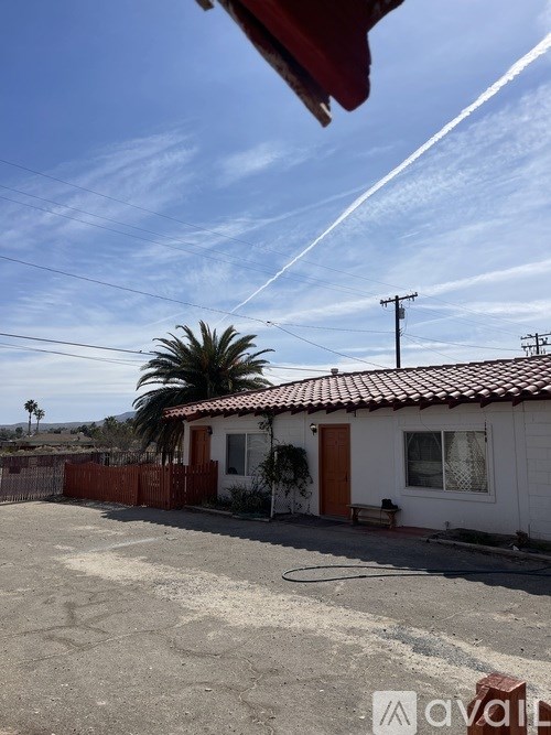 A house with a red roof and a white wall with a window and a door.