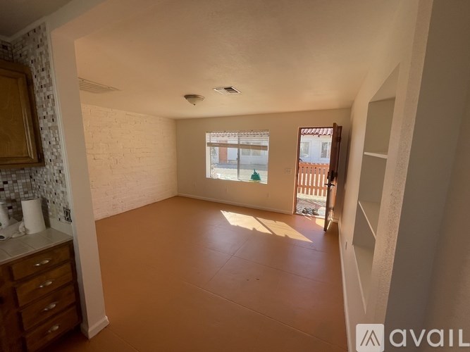 A room with a window and a door leading outside.