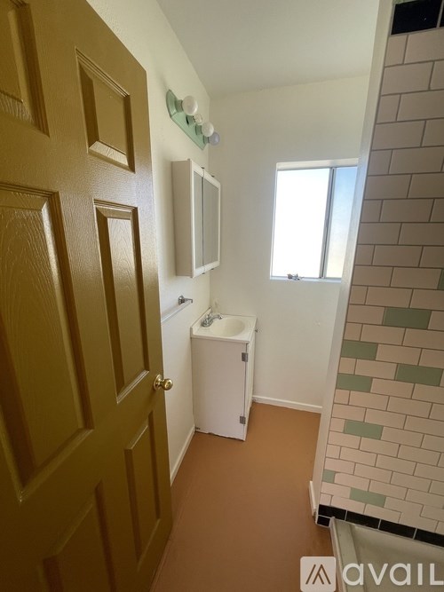 A bathroom with a brown door and a white cabinet.