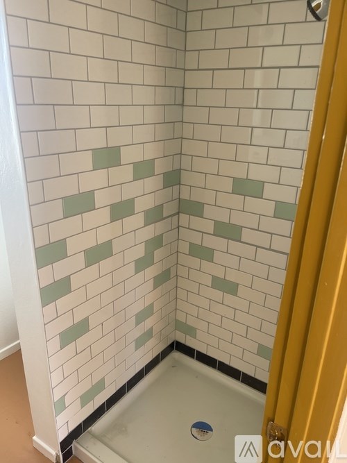 A bathroom with a shower and a yellow shower curtain.