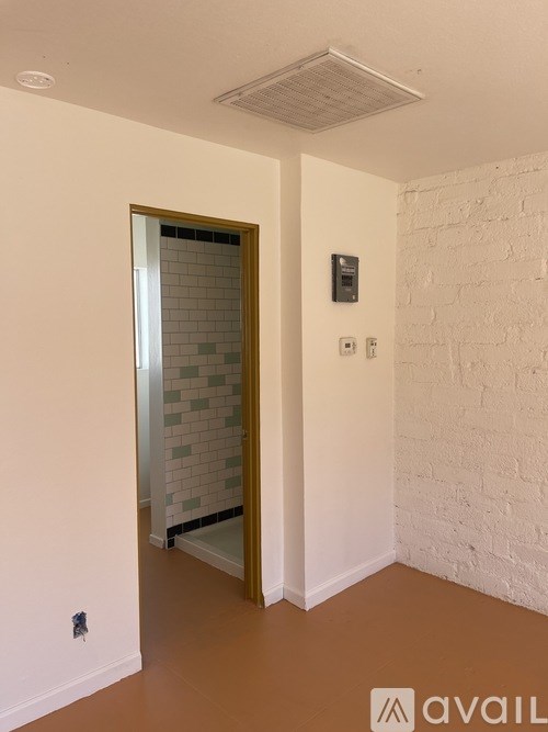 A room with a white brick wall and a brown floor.