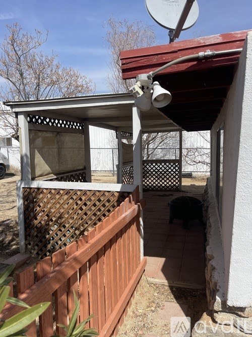 A patio with a lattice top and a satellite dish on the roof.