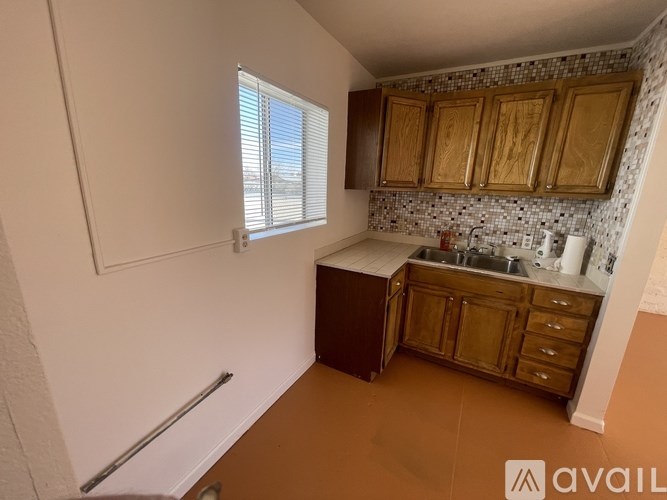 A kitchen with wooden cabinets and a tiled backsplash.