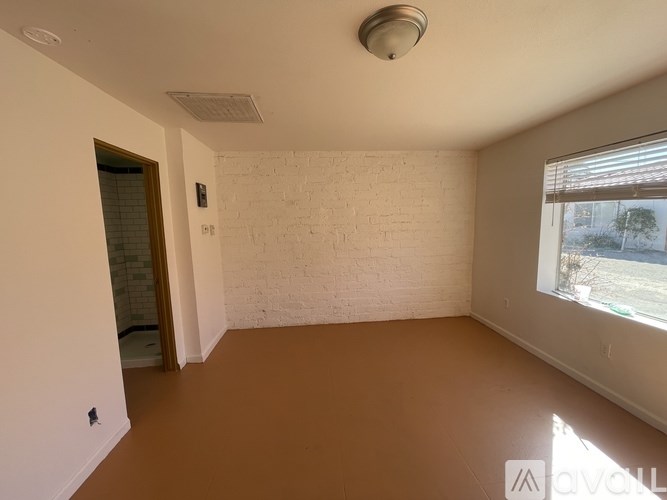 A room with a white brick wall and a window.