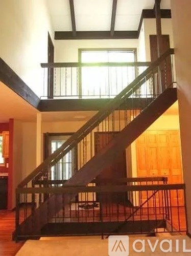 A staircase with a black railing and wooden steps.
