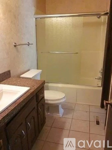 A bathroom with a toilet, sink, and shower.