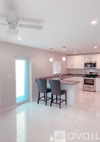 A modern kitchen with a dining table and chairs.