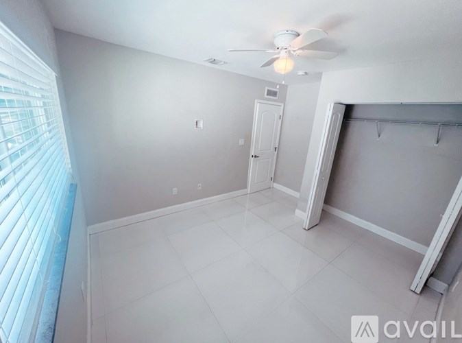 A room with a ceiling fan and a door.