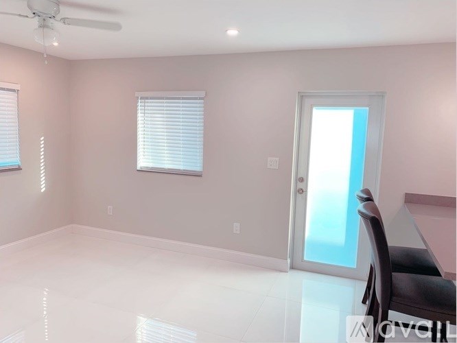 A room with a ceiling fan and a table with a chair.