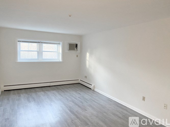 A room with a window and a grey floor.