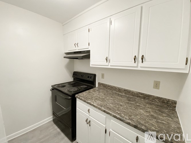 A kitchen with white cabinets and a black stove top oven.