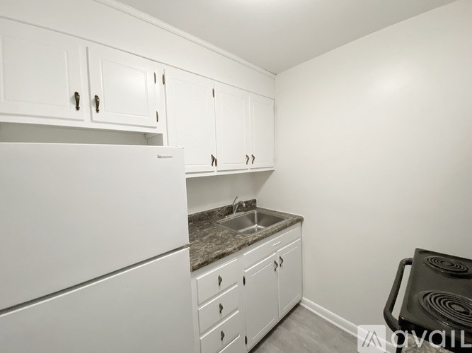 A kitchen with white cabinets and a white refrigerator.