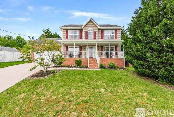A two-story house with a red and white exterior and a large front yard.
