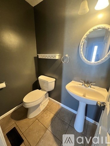 A bathroom with a toilet, sink, and mirror.