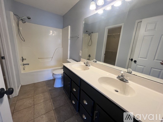 A bathroom with a white sink, a toilet, and a shower.