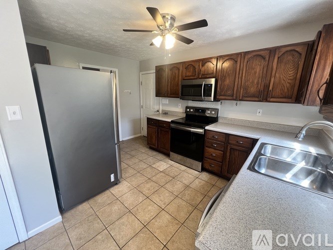 A kitchen with a refrigerator, sink, and stove.