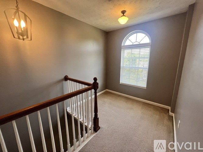 A room with a window and a chandelier.