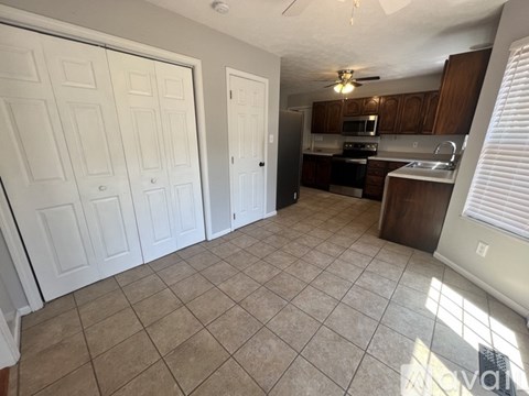 A kitchen with white cabinets and a tile floor.