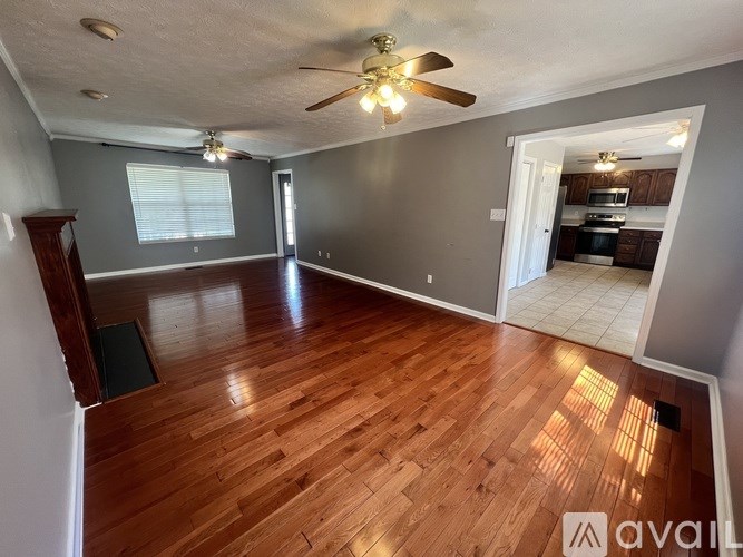 A room with wooden floors and a ceiling fan.