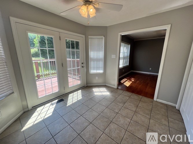 A room with a ceiling fan and a door leading to a deck.