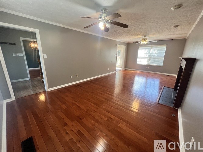 A room with wooden floors and a ceiling fan.