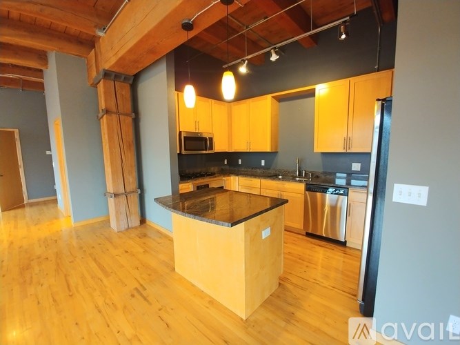 A kitchen with wooden floors and a central island.