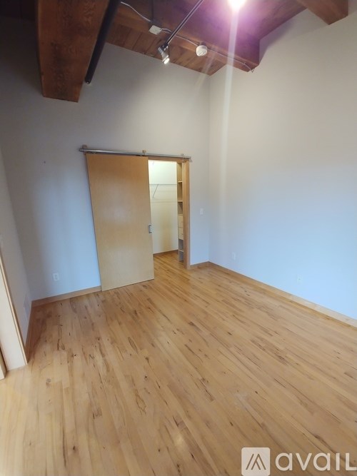 A room with wooden flooring and a sliding door.