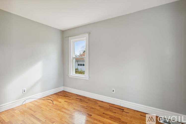 A room with a window and wooden flooring.