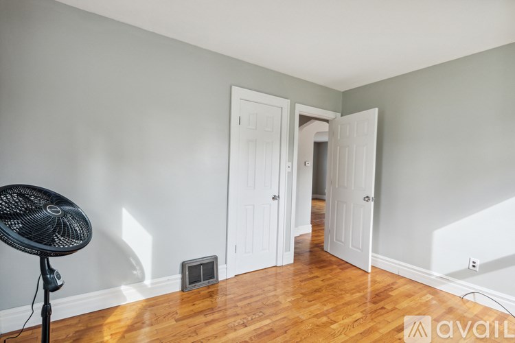 A room with a fan and two doors.