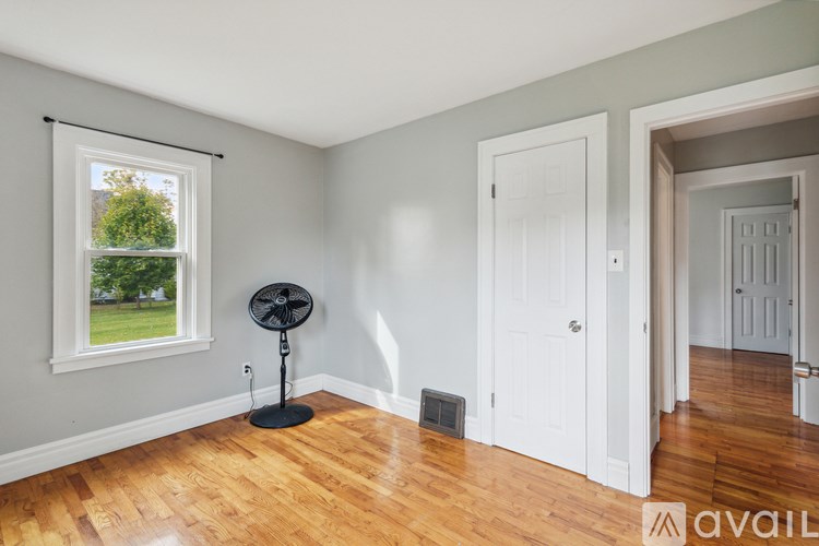 A room with a fan and a window.