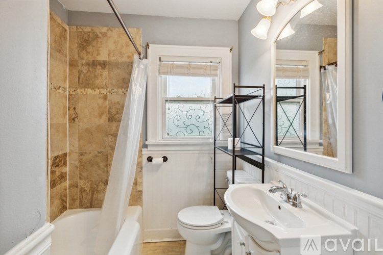 A bathroom with a white tub, toilet, and sink.
