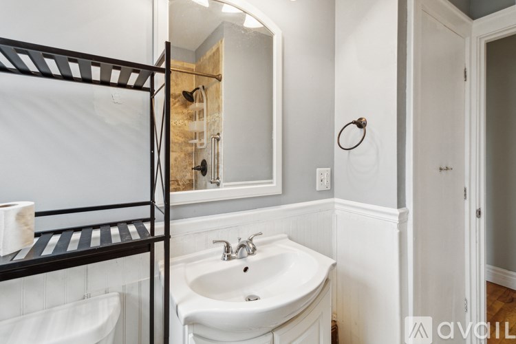 A bathroom with a white sink and a mirror.