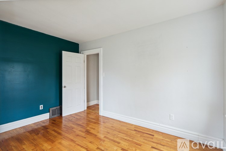 A room with a white door and a wooden floor.