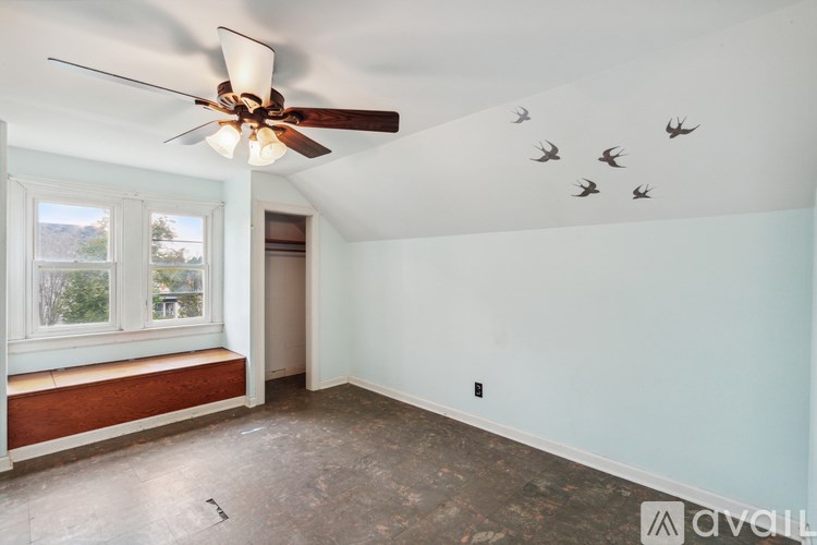 A room with a ceiling fan and a window.
