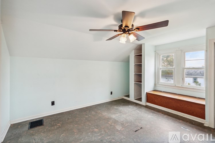 A room with a ceiling fan and a window.