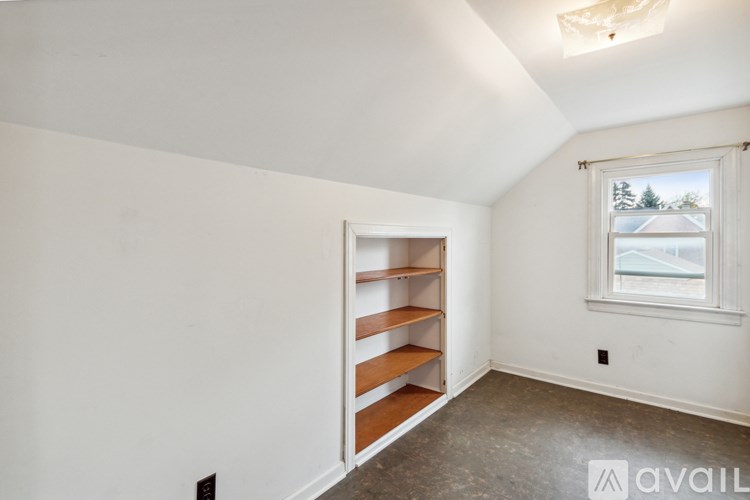 A room with a window and a shelf.