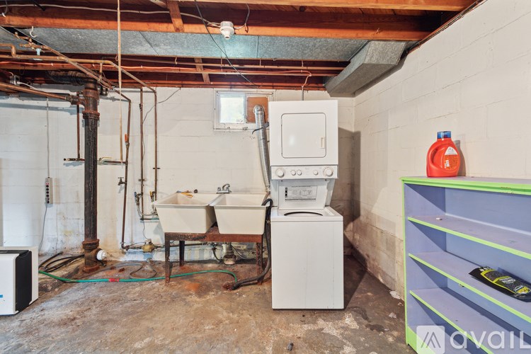 A dirty basement with a washer and dryer.