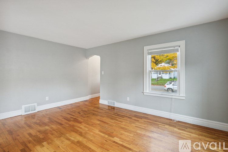 A room with wooden floors and a picture frame on the wall.