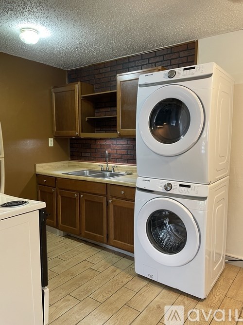 A white washing machine and dryer stacked on top of each other in a laundry room.