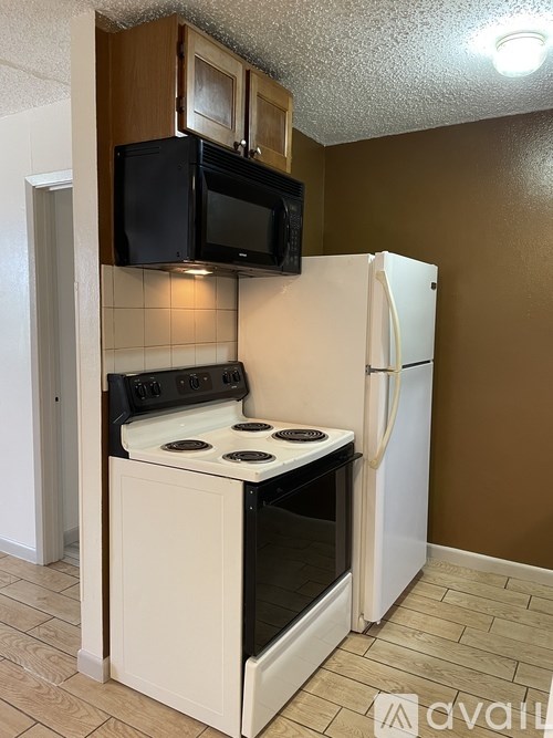 A kitchen with a white stove and refrigerator.
