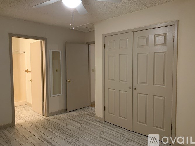 A room with a tiled floor and a ceiling fan with three lights.