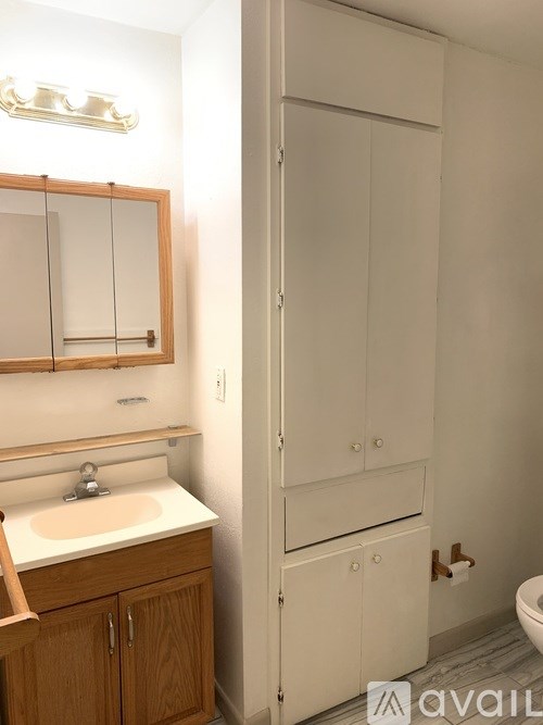 A bathroom with a sink, mirror, and medicine cabinet.