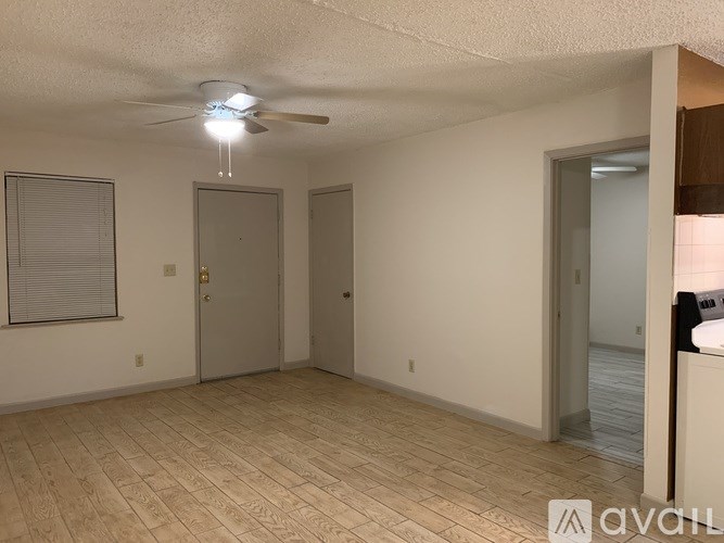 A room with a ceiling fan and wooden flooring.