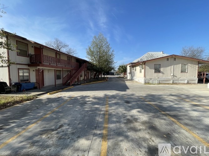 A parking lot in front of apartment buildings on a sunny day.