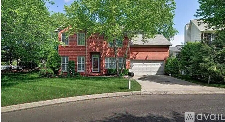 A red brick house with a white garage door is for sale.